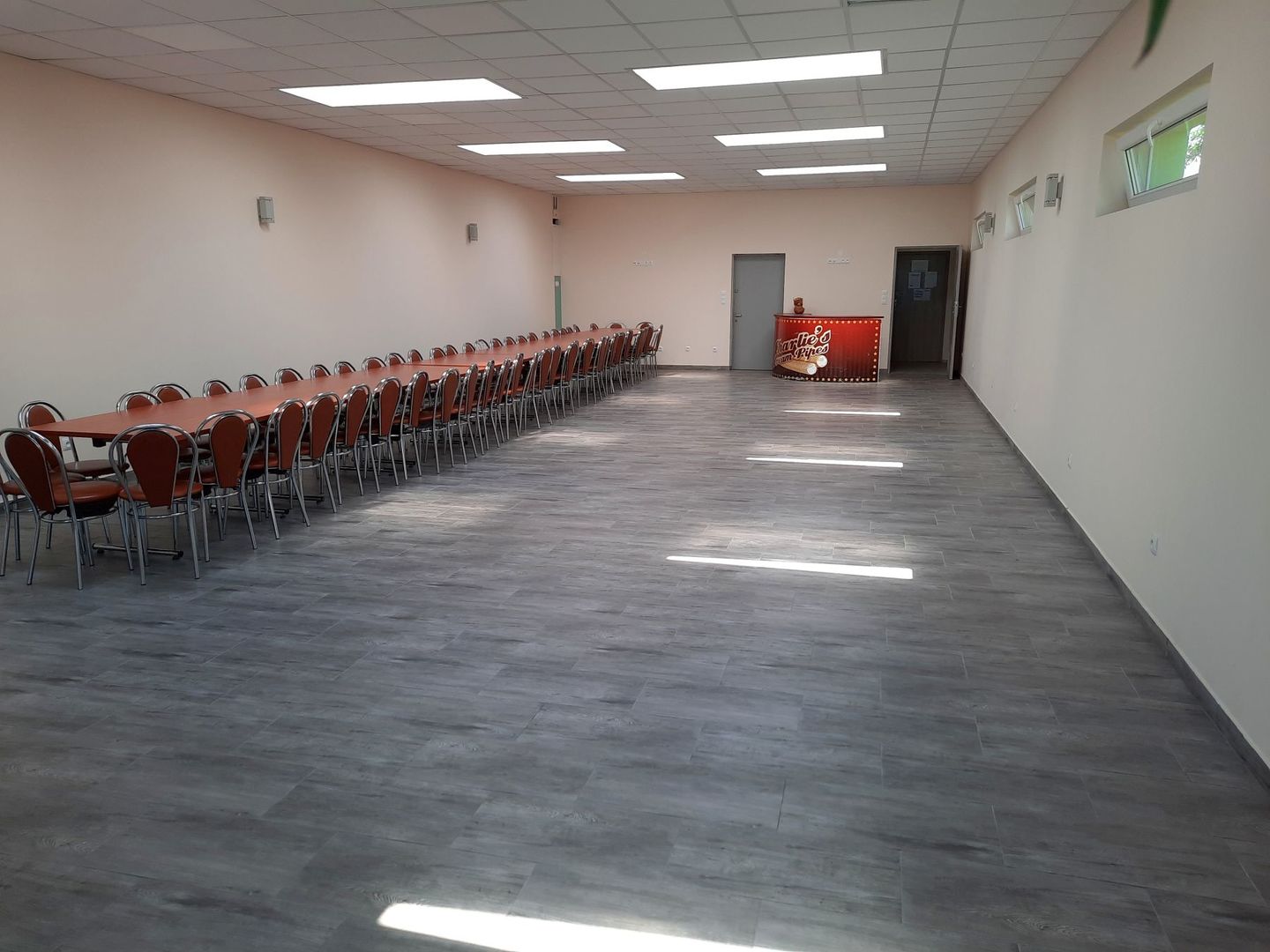 Sala główna po remoncie, nowa podłoga, po lewej stół i krzesła.