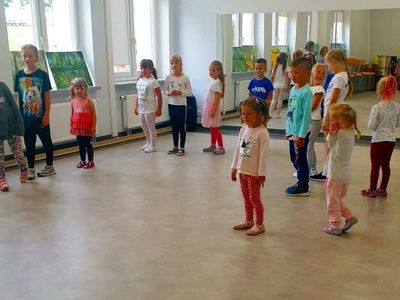 Grupa dzieci w kółku uczestniczy w zajęciach rytmiki w Świetlicy Kultury w Malechowie.
