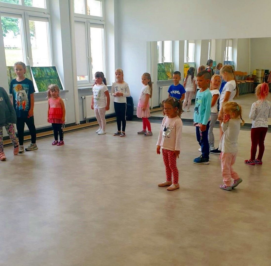 Grupa dzieci w kółku uczestniczy w zajęciach rytmiki w Świetlicy Kultury w Malechowie. 