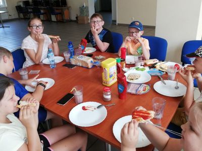 Dzieci z Placówki Wsparcia Dziennego w Pękaninie spożywają przy stole własnoręcznie wykonane tosty.