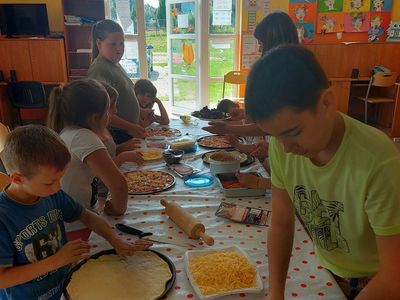 Wychowankowie z Placówki Wsparcia Dziennego w Laskach w trakcie wspólnego robienia pizzy.
