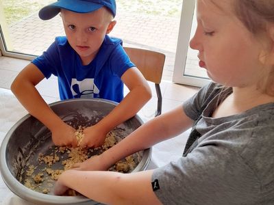Dziewczynka i chłopiec z PWD w Sulechowie, mieszają składniki na piasek kinetyczny.