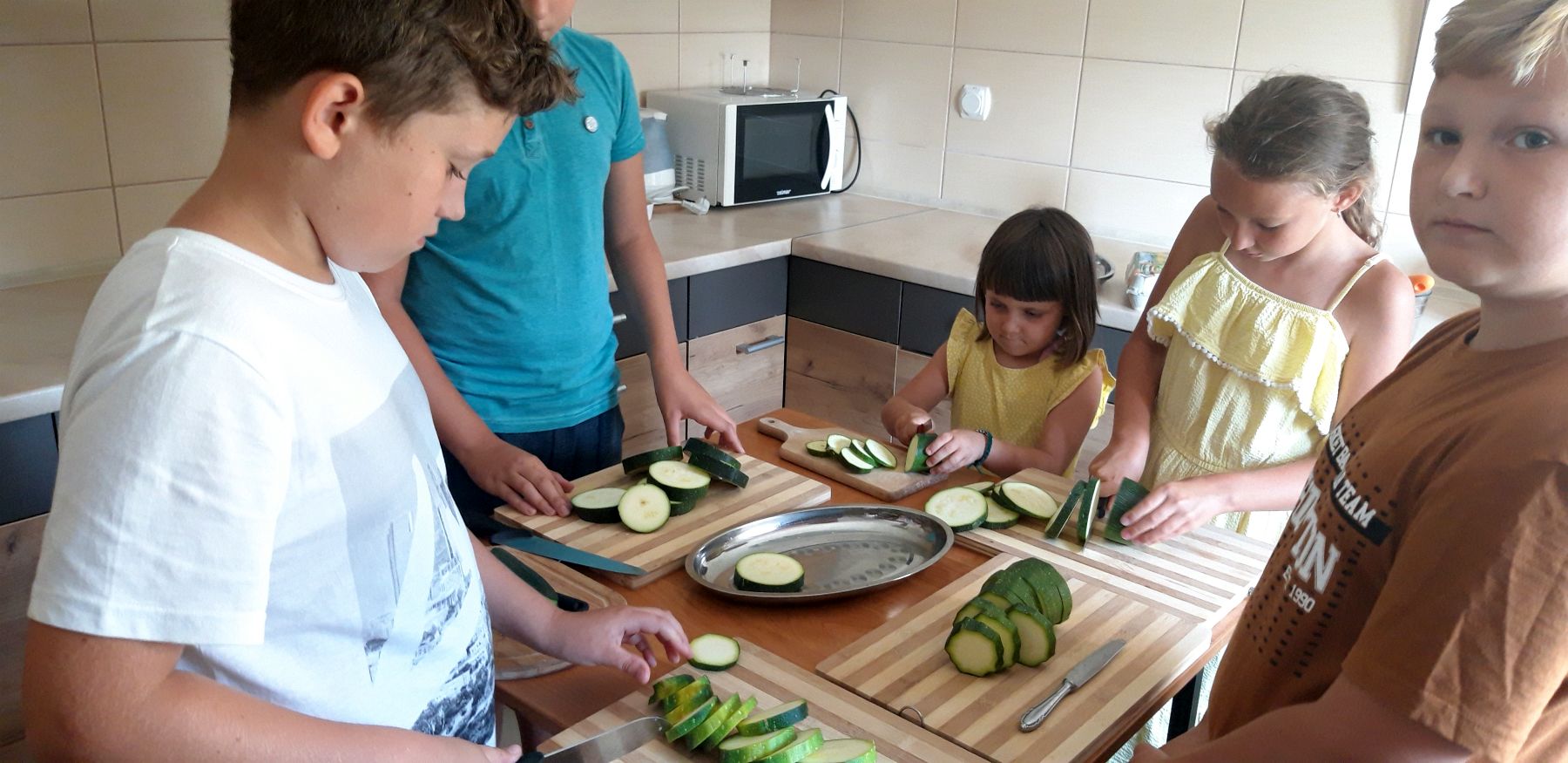 Dzieci z Placówki Wsparcia Dziennego w Kosierzewie podczas krojenia cukinii.