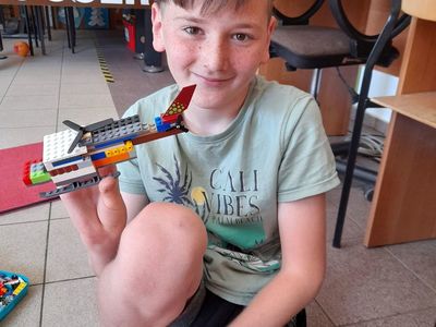 Chłopiec z Placówki Wsparcia Dziennego w Sulechowie  pozujący z helikopterem zbudowanym z klocków Lego.