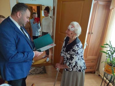 Wójt Radosław Nowakowski odczytuje oficjalny list gratulacyjny 95-letniej Genowefie Góraj.