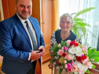 Wójt Radosław Nowakowski i 95-letnia Genowefa Góraj z kwiatami. 