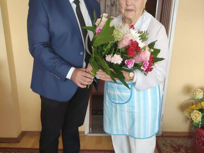 Wójt Radosław Nowakowski wręcza bukiet kwiatów 90-letniej Irenie Kosik z Kosierzewa.