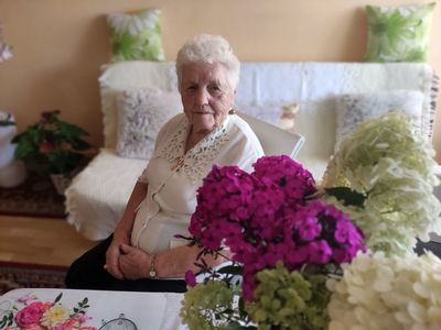 Irena Kosik, 90-latka z Kosierzewa, na pierwszym planie kwiaty w wazonie.