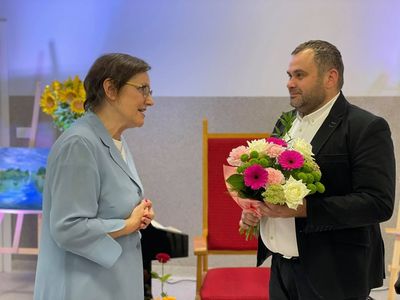 Elżbieta Kamińska i wójt Radosław Nowakowski, który składa jej gratulacje i wręcza kwiaty.