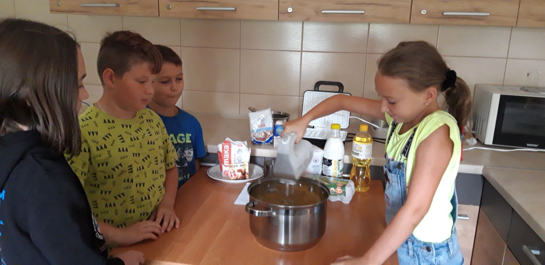 Dziewczynka z Placówki Wsparcia Dziennego w Kosierzewie przy użycia miksera wyrabia ciasto na gofry.
