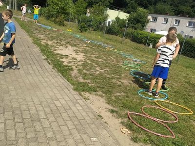 
Dzieci z Placówki Wsparcia Dziennego w Laskach skaczą przez tor z hula-hop