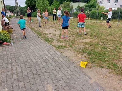 Dzieci z Placówki Wsparcia Dziennego w Laskach skaczą przez tor z hula-hop.
