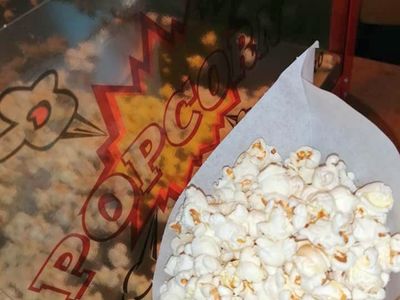 Popcorn i maszyna do popcornu w tle. 