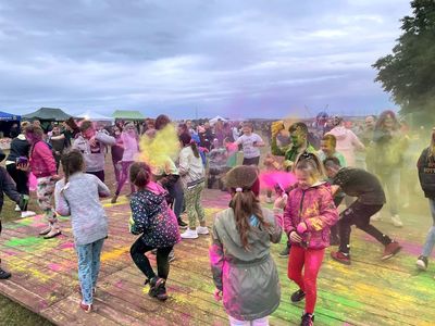 Dzieci podczas głównego punktu Malechowiady - Festiwalu Kolorów - obsypują się kolorowymi proszkami.