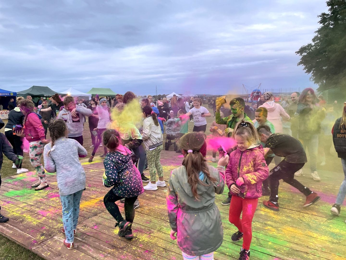 Dzieci podczas głównego punktu Malechowiady - Festiwalu Kolorów - obsypują się kolorowymi proszkami.