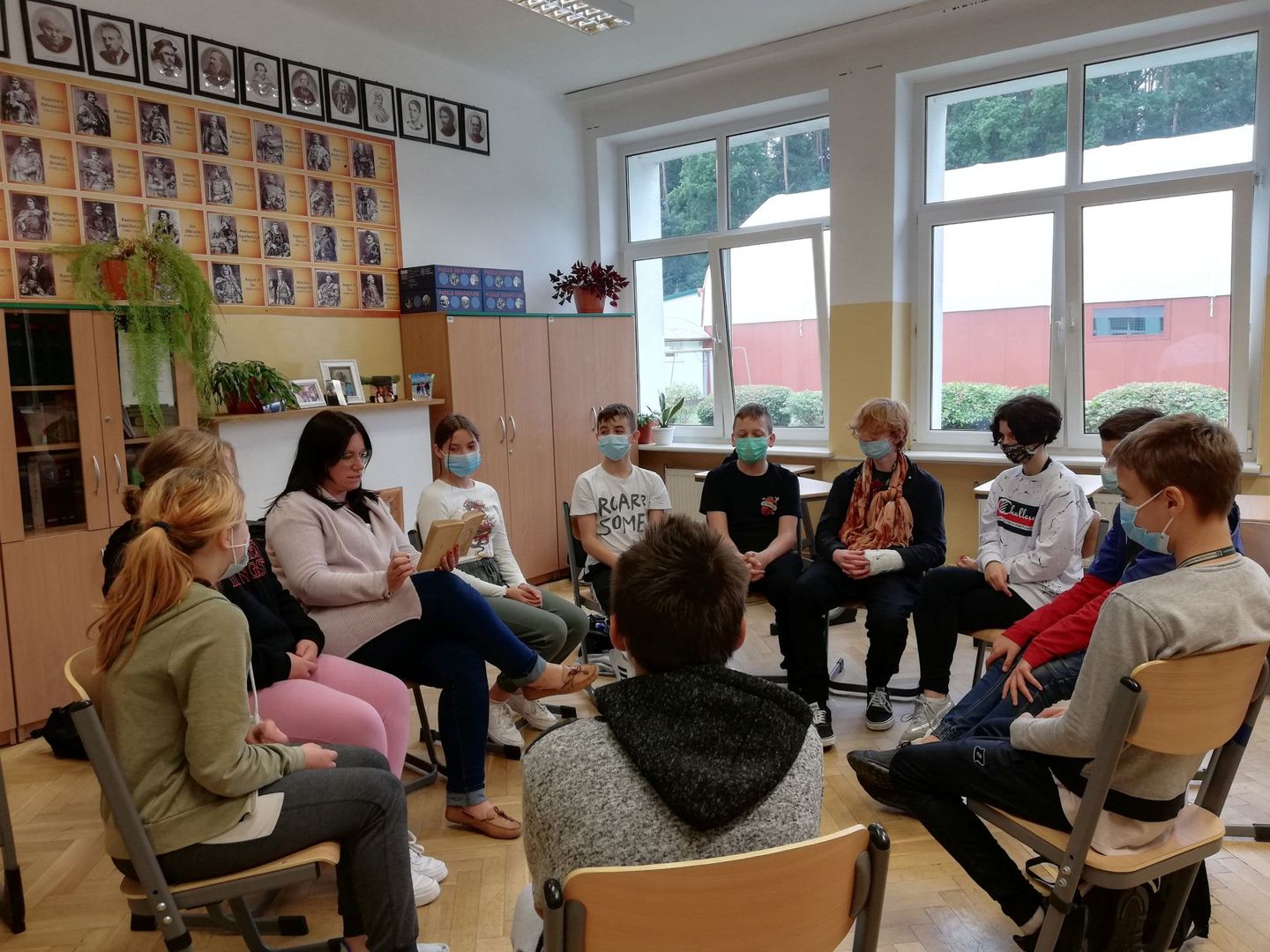 Wspólne czytanie utworu w Szkole Podstawowej w Lejkowie, dzieci w klasie z nauczycielką.