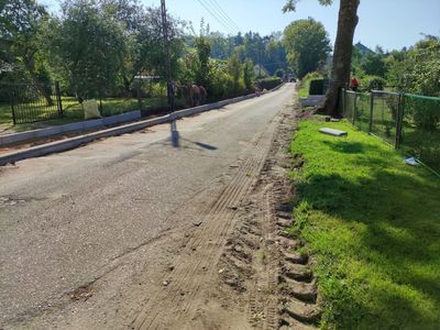 Remontowany odcinek drogi w Żegocinie, w tle pracownicy.