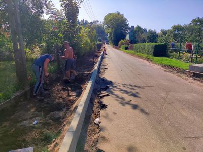 Remontowany odcinek drogi w Żegocinie i pracownicy w trakcie prac.