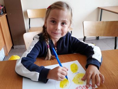 Dziewczynka z Placówki Wsparcia Dziennego w Sulechowie prezentująca wykonaną pracę plastyczną.