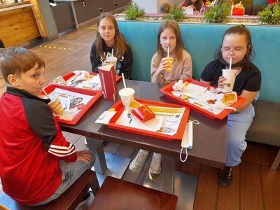 Trzy dziewczynki i jeden chłopiec z Placówki Wsparcia Dziennego w Sulechowie spożywający posiłek w restauracji.