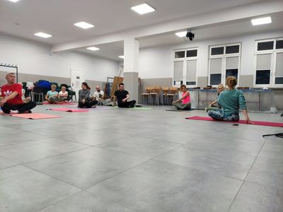Uczestnicy zajęć jogi ćwiczą w sali głównej Świetlicy Kultury w Malechowie. 