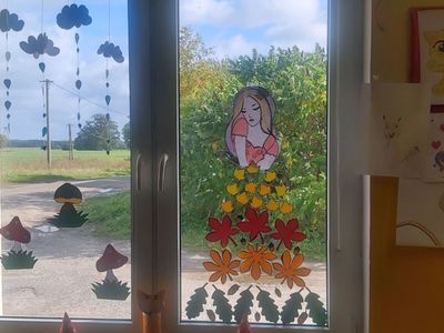 Ozdobione okno świetlicy: liście , grzyby, chmurki i pani jesień. 
