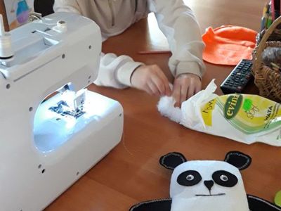 Dziewczynka z PWD w Kosierzewie podczas zajęć wypycha uszytą dynię watą.