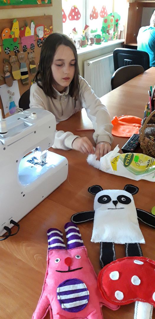 Dziewczynka z PWD w Kosierzewie podczas zajęć wypycha uszytą dynię watą.
