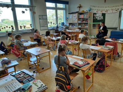 Mama Marcela z klasy pierwszej Szkoły Podstawowej w Malechowie czyta fragment książki, dzieci słuchają uważnie.