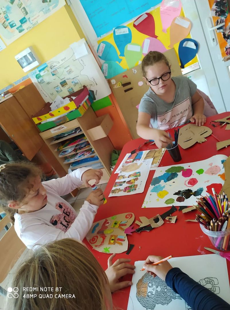 Dzieci z Placówki Wsparcia Dziennego w Laskach wykonują maski z tektury i kolorowych farb.