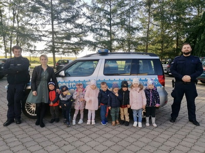 Grupa malechowskich przedszkolaków z wychowawcą oraz policjantami.