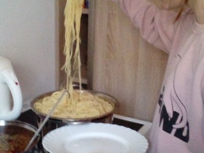 Dziewczynka z Placówki Wsparcia Dziennego w Ostrowcu przygotowuje makaron do spaghetti.