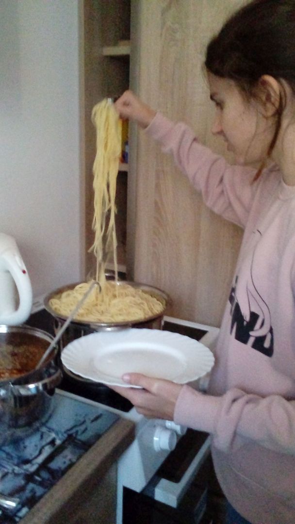 Dziewczynka z Placówki Wsparcia Dziennego w Ostrowcu przygotowuje makaron do spaghetti.