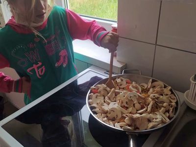 Dziewczynka z Placówki Wsparcia Dziennego w Laskach gotuje spaghetti.