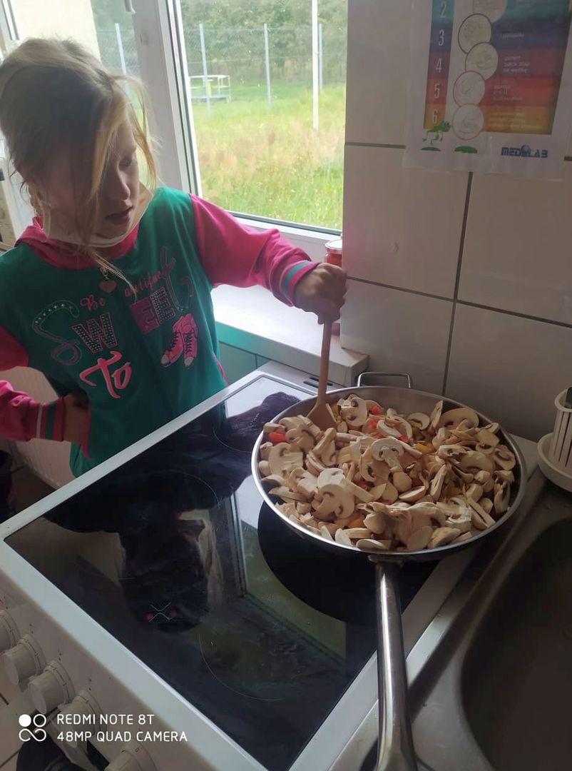 Dziewczynka z Placówki Wsparcia Dziennego w Laskach gotuje spaghetti.