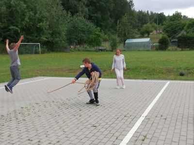 Przeskakiwanie przez linę jako przeszkodę w wykonaniu dzieci z Placówki Wsparcia Dziennego w Pękaninie.
