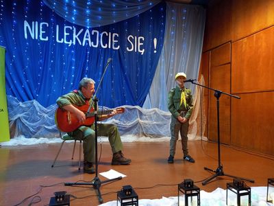 Na scenie druh Marek Jarosz gra na gitarze, obok niego śpiewająca harcerka.