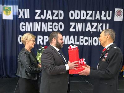 Wójt Radosław Nowakowski wręcz upominek ustępującemu Prezesowi Bohdanowi Pawlakowi, obok sekretarz Halina Skaza.