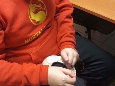 Chłopiec wykonujący jesienną ozdobę.