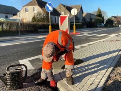 Pracownik w trakcie prac wykończeniowych na nowo wyremontowanym odcinku drogi w Malechowie. 