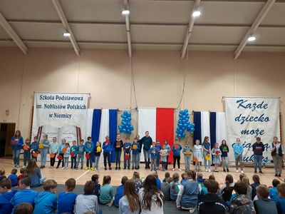Uczniowie ze Szkoły Podstawowej w Niemicy w czasie występu na sali gimnastycznej, spotkanie dotyczy „Prawa dziecka”.