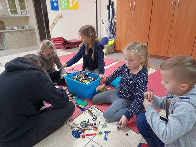 Trzy dziewczynki i jeden chłopiec z Placówki Wsparcia Dziennego w Sulechowie układają klocki Lego.