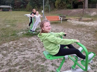 Trzy dziewczynki z Sulechowa ćwiczą na elementach siłowni zewnętrznej.