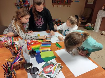 Dzieci z Placówki Wsparcia Dziennego podczas wykonywania kartek bożonarodzeniowych na konkurs plastyczny. 