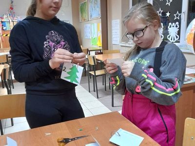 Dwie dziewczynki podczas odczytywania zadań z kalendarza adwentowego.