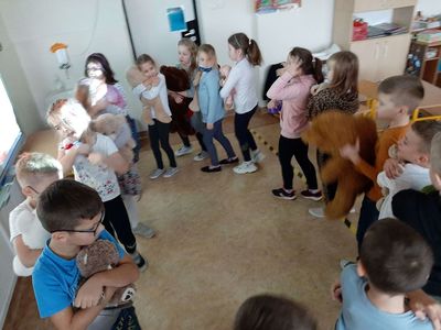 Pierwszaki z Zespołu Szkolno - Przedszkolnego w Malechowie tańczą w kółku z misiami.