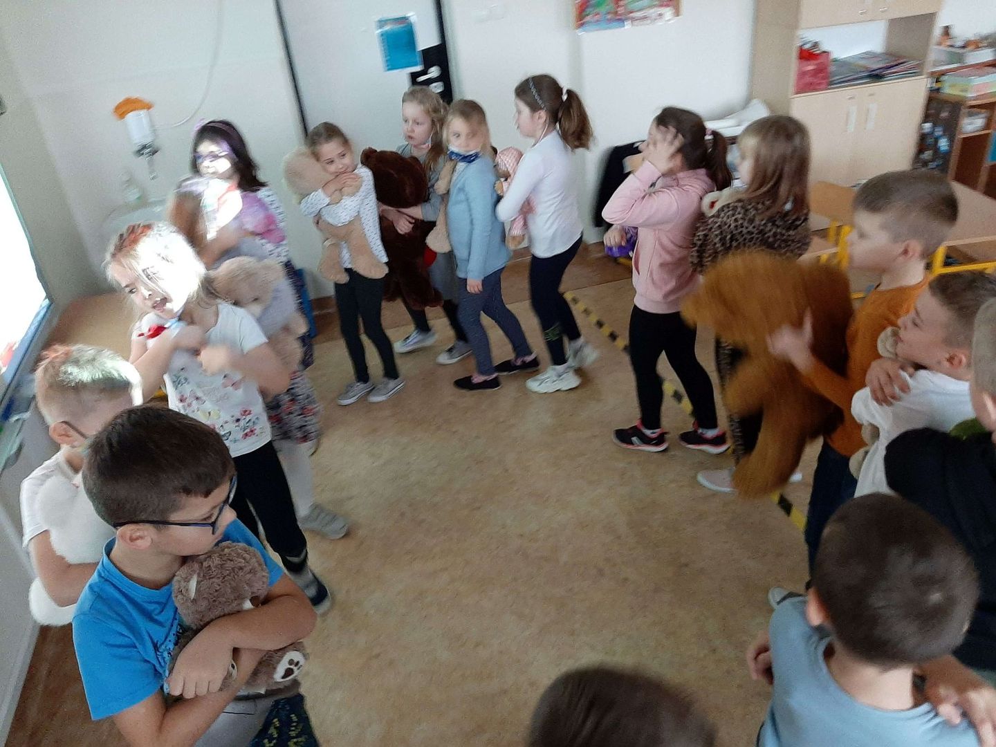 Pierwszaki z Zespołu Szkolno - Przedszkolnego w Malechowie tańczą w kółku z misiami.