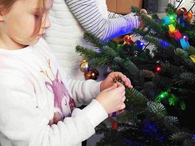 Wychowanki Placówki Wsparcia Dziennego w Kusicach podczas ozdabiania choinki.