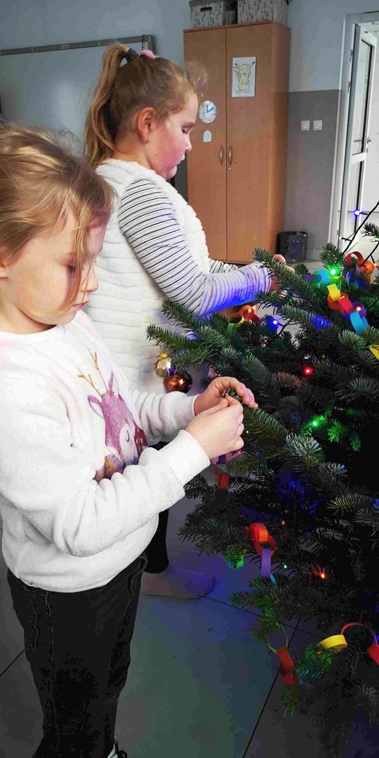 Wychowanki Placówki Wsparcia Dziennego w Kusicach podczas ozdabiania choinki.