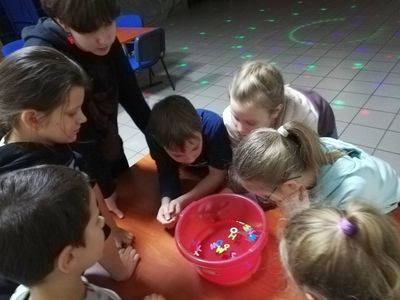 Dzieci z Placówki Wsparcia Dziennego w Pękaninie podczas wróżb andrzejkowych z woskiem.